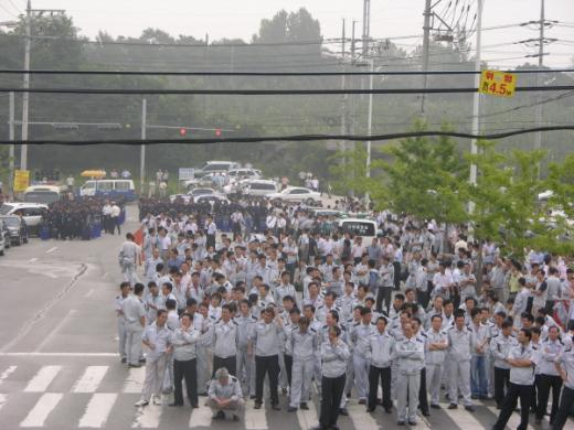 ↑월요일 아침, 평소대로 출근하던 관리직 사무원들이 본관으로 들어가지 못하고 정문앞 큰길가에서 대기하고 있다. 이들은 본사 방침에 따라 공장 인근에 있는 출고사무소 등으로 이동했다.