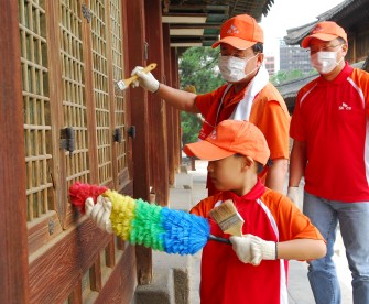 ▲SK건설 유웅석 사장과 직원 자녀가 덕수궁 고건물의 
먼지를 털고 있다.