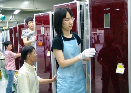 LG전자 창원공장 직원들이 에어컨 제품을 꼼꼼히 살피고 있다. 창원공장 일부 에어컨 라인은 이번주부터 2교대로 24시간 풀가동되고 있다.