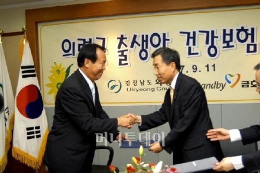 ↑김채용 의령군수(왼쪽)와 금호생명 최병길 대표이사가 출생아 보험 지원 협약을 체결하고 있다.