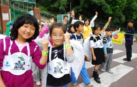 신흥초등학교 2학년 1반 학생들이 반사재 팔찌를 차고 횡단보도를 건너는 시연을 하고 있다.