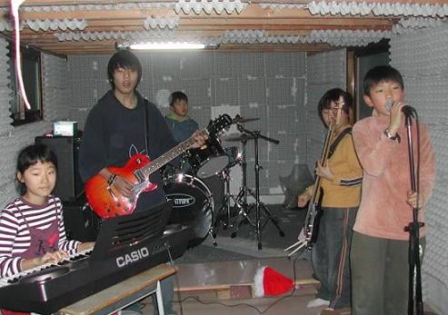 ↑꿈터 그룹사운드 '언저리스'가 동네 아이들을 모아 공연하고 있다. 이 음악실은 원두막 아래 빈공간에 아이들이 직접 계란판을 붙여 만들었다. ⓒ꿈터