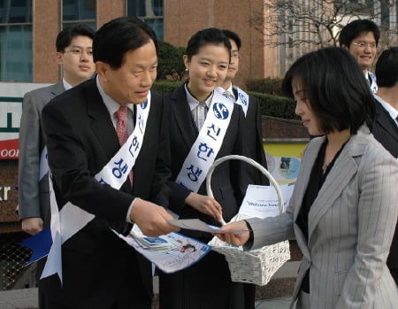 ↑신한생명 서진원 사장이 은퇴설계 프로젝트 홍보를 위해 서울 종각역 앞에서 고객들에게 꽃씨를 나눠주고 있다.