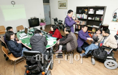 정회창 IT서포팀장(오른쪽에서 첫번째) 등 IT서포터즈팀이 휠체어에 앉아있는 이학현 용인자립생활센터 홍보팀장과 함께 사진 촬영을 하고 있다. ⓒ홍봉진 기자 hanggga@