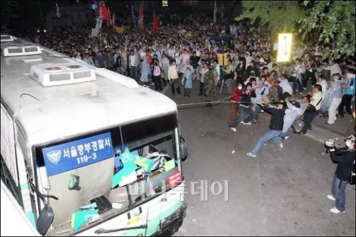 ↑시위대가 전경버스를 쓰러뜨리려 하고 있다.