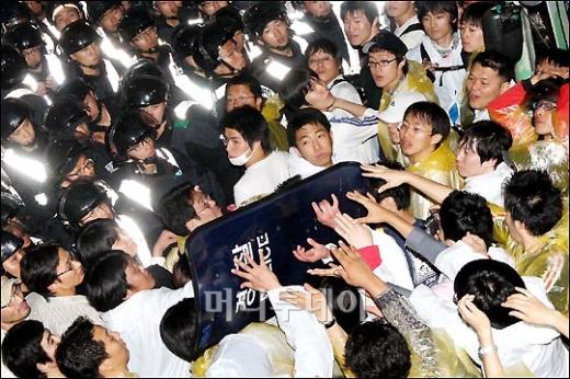 ↑시위대가 경찰의 방패를 빼앗고 있다.