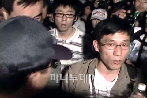 ↑일부 시위대가 두 중년남성(사진 좌측)을 이른바 '프락치'로 지목해 억류하자 진중권 교수가 나서 중재하고 있다. 머니투데이 촬영 동영상 캡쳐화면 ⓒ조철희기자