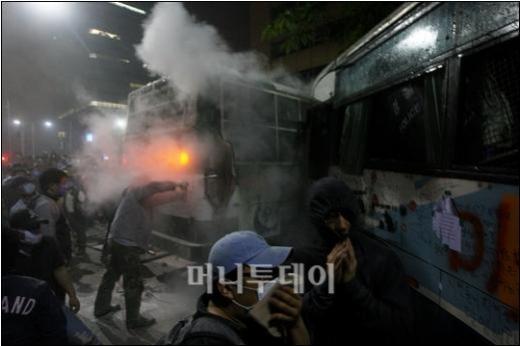 ▲8일 새벽 세종로 사거리에서 경찰이 전경차량을 이용한 저지선을 뚫으려는 촛불집회 참가자들에게 소화기를 분사하고 있다. 경찰이 일부 시민을 연행하면서 촛불시위는 8일 오전 1시 이후 격렬한 양상을 보이고 있다. ⓒ이명근 기자