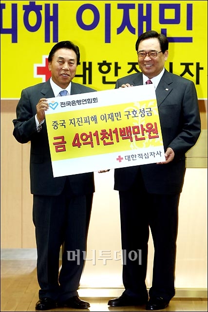 ↑전국은행연합회 회장 유지창(왼쪽)과 대한적십자사 총재 이세웅이 성금전달식을 하며 포즈를 취하고 있다.