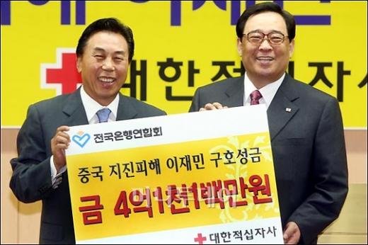 ↑전국은행연합회 회장 유지창(왼쪽)과 대한적십자사 총재 이세웅이 성금전달식을 하며 포즈를 취하고 있다.
