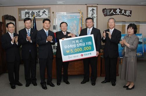 최민호 경남은행 부행장(왼쪽에서 네번째)이 김한겸 거제시장(오른쪽 세번째)에게 장학금 기탁증서를 전달한 후 기념 촬영을 하고 있다.