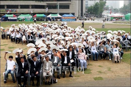 ↑에너지시민연대 이덕승 공동대표를 비롯해 경제4단체(전경련, 대한상의, 무역협회, 중소기업중앙회) 대표와 이윤호 지식경제부 장관, 서울시 관계자 등 모두 300여명이 참석해 한반도 모양으로 앉아 부채를 흔들고 있다.