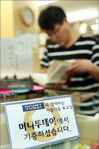 ↑ 아름다운 가게를 찾은 시민이 책을 고르고 있다.