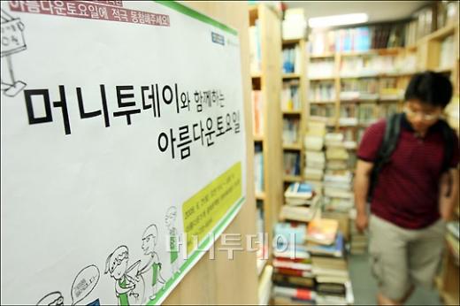 ↑아름다운 가게를 찾은 시민이 책을 고르고 있다.