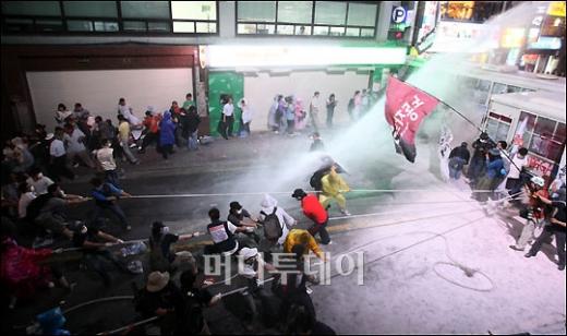 ↑26일 오후 미국산쇠고기 수입반대 촛불시위 참가자들이 경찰버스를 끌어내려 하자 경찰이 살수차로 물대포를 쏘고 있다. ⓒ임성균 기자