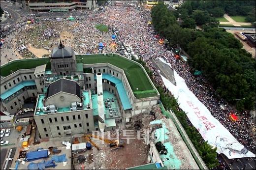 ↑28일 오후 서울시청 앞 광장에서 열린 미국산 쇠고기 수입반대 촛불시위에 참석한 시민들이 명박산성이라 적힌 현수막을 찢고 있다. ⓒ홍봉진 기자
