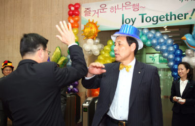 ▲ 김정태 하나은행장은 지난 4월 서울 을지로 본점 로비에서 파티용 모자를 쓴 채 출근하는 직원들과 하이파이브를 했다.