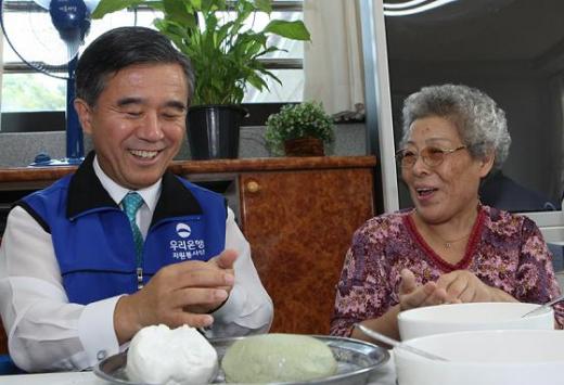 '희망의 마을'을 방문한 이종휘 우리은행장이 무의탁 노인들과 송편을 빚고 있는 모습