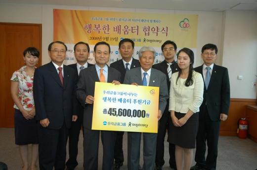 우리금융그룹 이팔성 회장(가운데 왼쪽)이 어린이재단 김석산 회장(가운데 오른쪽)에게 후원금을 전달하는 모습