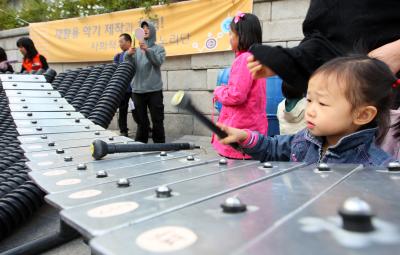 ↑"내 연주 어때요?"
26일 청계천변에서 한 어린이가 재활용퍼포먼스그룹 노리단의 재활용악기를 두드리며 몰입하고 있다. 이명근 기자 qwe123@