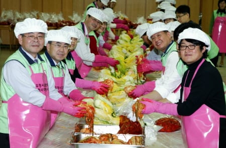 ↑정경원 우정사업본부장(왼쪽 맨앞)과 가수 김현철(오른쪽 맨앞)이 전국 쉼터보호아동을 위해 사랑의 김장을 담그고 있다. (사진제공: 우정사업본부)