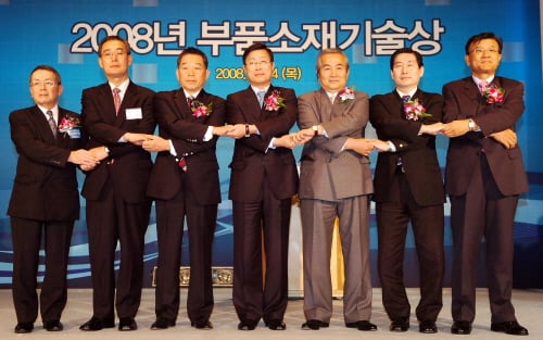 ↑2008년 부품소재기술상 시상식에서 이윤호 지식경제부 장관과 한국과 일본의 부품소재 관련 기업 대표들이 손을 맞잡고 한일 기업 간의 상생협력을 다짐하는 선포식을 하고 있다. 왼쪽부터 요시히로 후카세 GSI CREOS 상무, 허영호 LG이노텍 사장, 나카지마 히로카즈 고덴시 회장, 이윤호 지식경제부장관, 무카이 신이치 우치다양행 회장, 성창모 효성기술원장, 정준석 한국부품소재산업진흥원장.