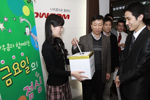 ↑나우콤 김대연 사장(보안사업 부문)이  금요일의 점심 모금함에 성금을 넣고 있는 모습.