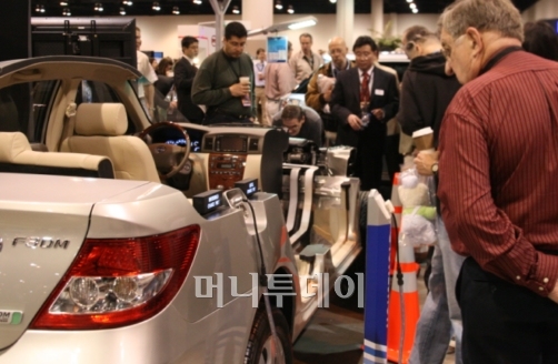 ↑버크셔 해서웨이 주총장에 등장한 중국 비야디(BYD)자동차의 전기차 F3DM을 관람객들이 관심있게 쳐다보고 있다.[오마하=김준형 특파원]