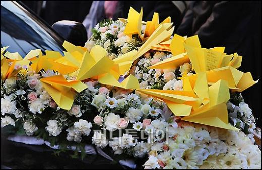 ↑ 노무현 전 대통령 영결식이 진행되는 29일 오전 경남 김해시 진영읍 본산리 봉하마을에서 노 전 대통령의 운구 차량 위에 추모객들이 접여 날린 노란색 비행기가 쌓여 있다.ⓒ봉하=사진공동취재단