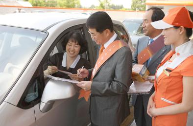 ↑구자용 E1 부회장이 12일 과천충전소에서 고객에게 오렌지카드를 설명하고 현장 발급을 하고 있다.