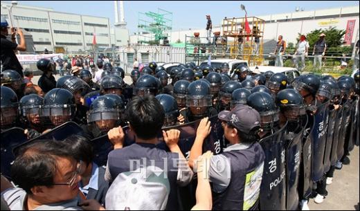 ↑24일 오전 경기 쌍용자동차 평택공장에서 경찰병력이 공장출입을 통제하고 있는 가운데 노조원들이 공장에 진입하기 위해 몸싸움을 벌이고 있다. ⓒ이명근 기자
