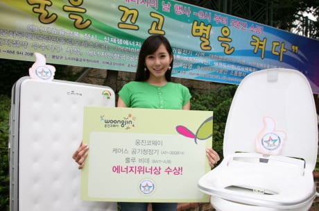 ↑웅진코웨이 관계자가 19일 '에너지의 날' 시민행사에서 '올해의 에너지상'을 수상한 청정기와 비데를 소개하고 있다.
