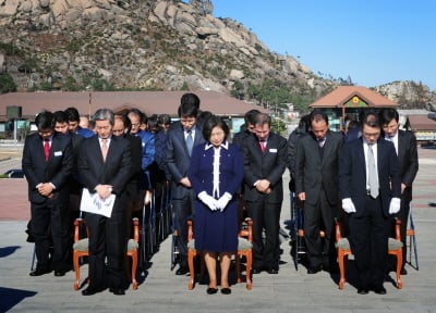 ↑현정은 현대그룹 회장(앞줄 가운데)이 18일 금강산관광 11주년 현지 기념행사에 참석해 고(故) 정몽헌 회장 추모비에 참배를 하고 있다.