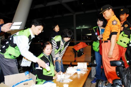 15일 인천국제공항에서 아이티 긴급구호대가 출국에 앞서 일회용 주사기 등 구조 물품을 점검하고 있다.