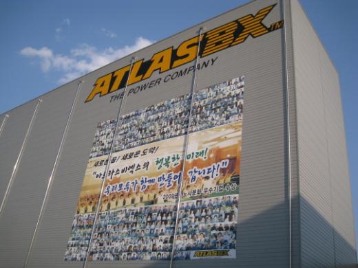 ↑ 아트라스BX 대전본사 정문 앞 공장 벽에 전 직원들의 얼굴이 새겨진 대형 현수막이 걸려 있다. ⓒ대전=박종진 기자.