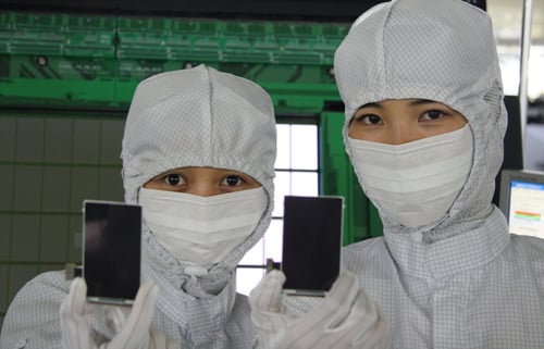 ↑삼성모바일디스플레이 직원이 천안사업장 라인에서 프리미엄급 AMOLED 패널을 들어 보이고 있다. <사진제공=SMD>