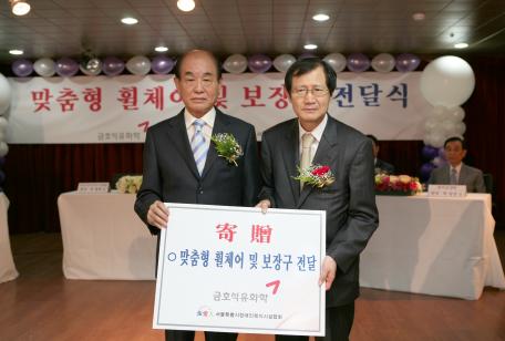 ↑금호석유화학이 23일 서울특별시장애인복지시설협회와 공동으로 서울 노원구 상계1동 소재 중증장애아동생활시설인 쉼터요양원에 특수제작 맞춤형 휠체어와 보장구를 기증하는 행사를 개최했다. 정명규 서울특별시장애인복지시설협회장(왼쪽)과 박찬구 금호석화 회장.