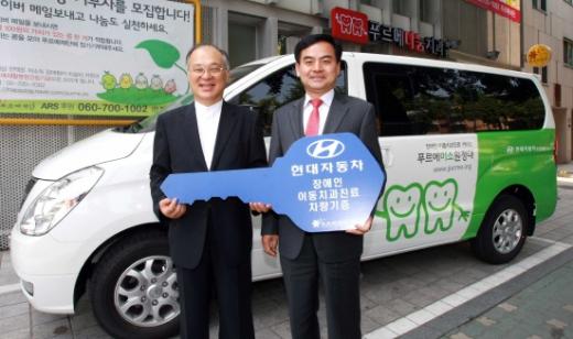 ↑현대차는 지난 24일 서울 신교동에 위치한 비영리법인 운영 장애인 치과인 푸르메 나눔치과에 휠체어 리프트가 장착된 스타렉스 1대와 이동이 가능한 치과 진료 장비 2세트를 기증했다. 사진 왼쪽부터 강지원 푸르메재단 공동대표와 이영복 현대기아차 사회문화팀장이 포즈를 취하고 있다.