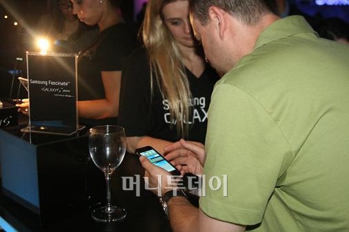 ↑29일(현지시간) 뉴욕 맨해튼 36번가 서쪽 스카이라이트 웨스트에 열린 삼성 갤럭시 S 런칭행사에서 한 사용자가 갤럭시S를 요모조모 살피고 있다.(사진=머니투데이)