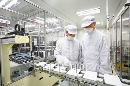 ↑세계 최초·최대규모의 LG화학 오창 전기차 배터리 공장에서 직원들이 생산된 제품을 살펴보고 있다.