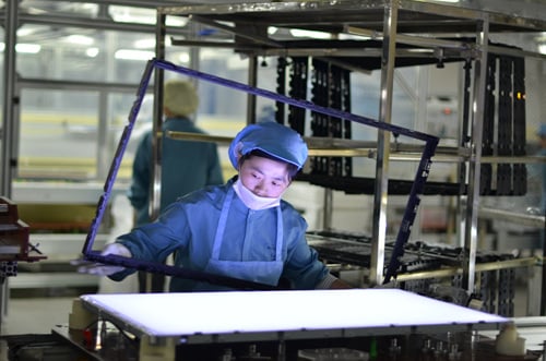 ↑백라이트 공정에서 여직원이 백라이트 시트를 검수하고 있다.