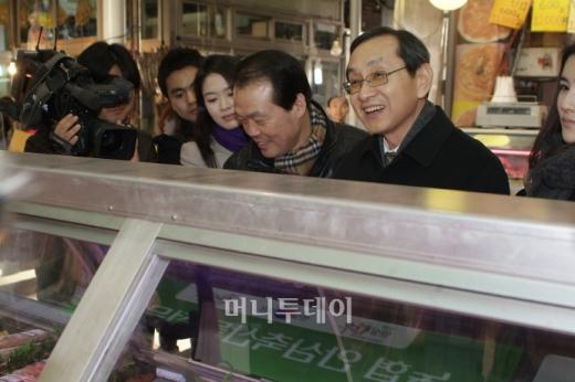 김동수 공정거래위원장이 관악구 신원시장 내 정육점에서 돼지고기를 구입하고 있다.(*사진제공:공정거래위원회)