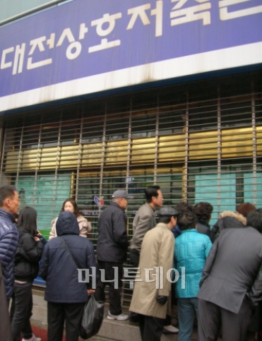 17일 금융위원회로부터 영업정지를 받은 대전상호저축은행 대전둔산지점에 돈을 맡긴 고객들이 몰려와 출입문 앞에 붙은 안내문을 보며 불안해 하고 있다.