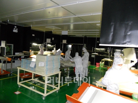 지난달 31일 신화인터텍 중국 동관 법인에서 작업자들이 광학필름의 품질을 확인하는 검사 공정을 진행하고 있다.