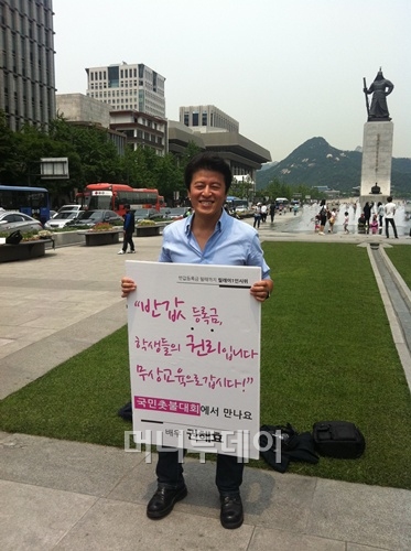 배우 권해효가 7일 정오 서울 광화문광장에서 반값등록금 시행 촉구 1인시위를 벌이고 있다.