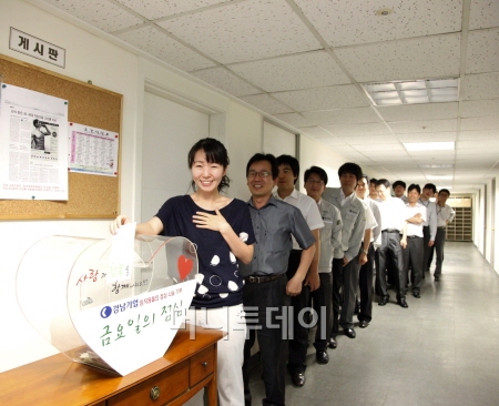 ↑경남기업 임직원들이 금요일의 점심 모금함에 점심값을 아껴 모금을 하고 있다.