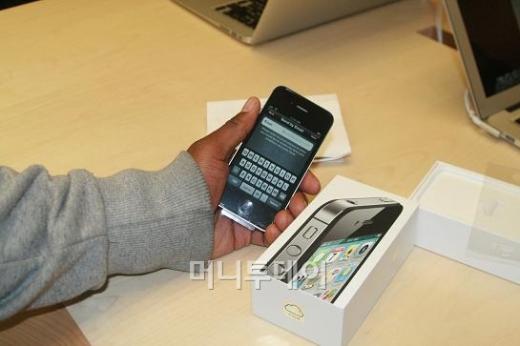↑14일(현지시간) 출시된 아이폰 4S를 구입, 개통한뒤 시연하는 한 고객.