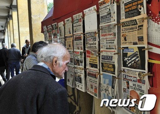 그리스 국민투표 결정이 내려진 1일(현지시간) 아테네에서 한 노인이 신문을 보고 있다. AFP  News1