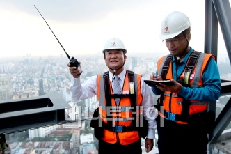 ↑금호건설의 김성인(왼쪽) 베트남 호찌민 '타임스퀘어' 현장 소장이 꼭대기에 올라 작업 사항을 지시하고 있다.