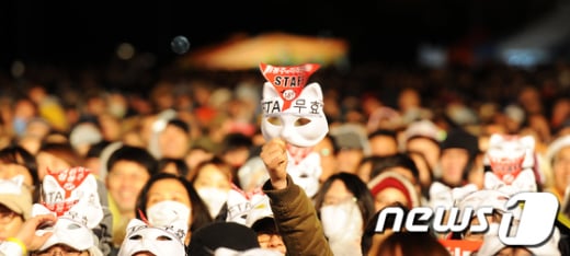 한미FTA 비준 무효화를 촉구하는 ‘나는꼼수다’ 특별콘서트가 열린 30일 저녁 서울 영등포구 여의공원에서 시민들이 공연을 관람하고 있다. (서울=뉴스1) 박지혜 인턴기자